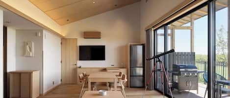 Un interior moderno con comedor, televisor de pantalla plana y vistas al exterior.