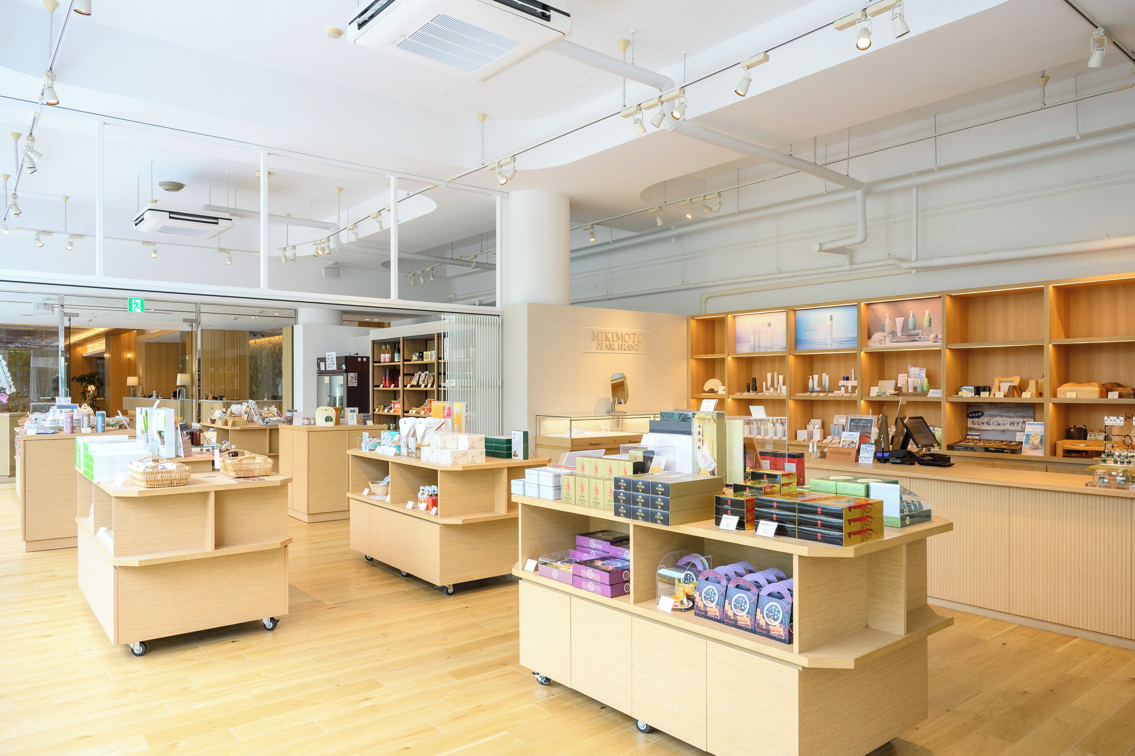 Un grand magasin spacieux doté d’un plancher en bois et où une grande variété de produits sont exposés.