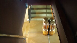 A staircase with a handrail, leading to a landing where a set of decorative glass bottles is placed. - Coffee Island - Hostel (Koh Samui)