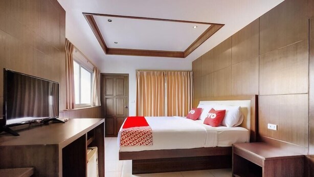 A hotel room with a bed, a TV, a desk, and a wardrobe. - Chytalay Palace Hotel (Koh Samui)