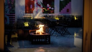 A patio area with a fire feature, outdoor seating, and a mural on the wall. - Jill Hotel Brussels (Brussels)