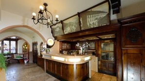 A spacious kitchen with a central island, wooden cabinetry, and a chandelier. - Gasthof Sonne (Imst)