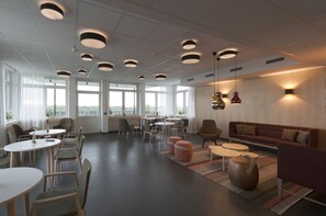 A modern interior with round tables, chairs, a sofa, and a decorative vase.