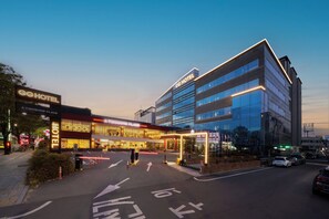 A hotel with a modern facade, multiple floors, and a well-lit entrance. - Gyeongju GG Tourist Hotel (Gyeongju)