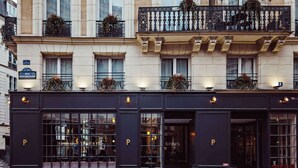 A building with large windows, a dark facade, and outdoor seating. - Hotel Panache (Paris)
