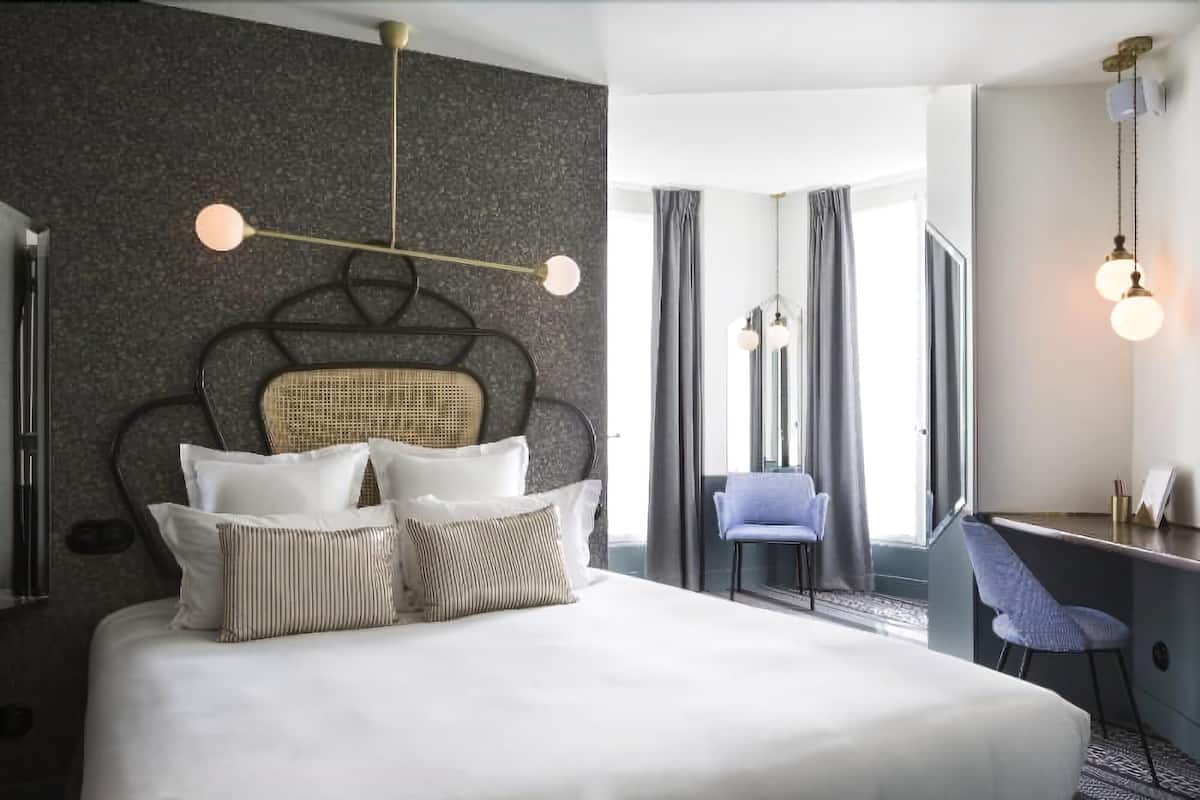 Et moderne hotelværelse med en stor seng, et skrivebord og en stol.