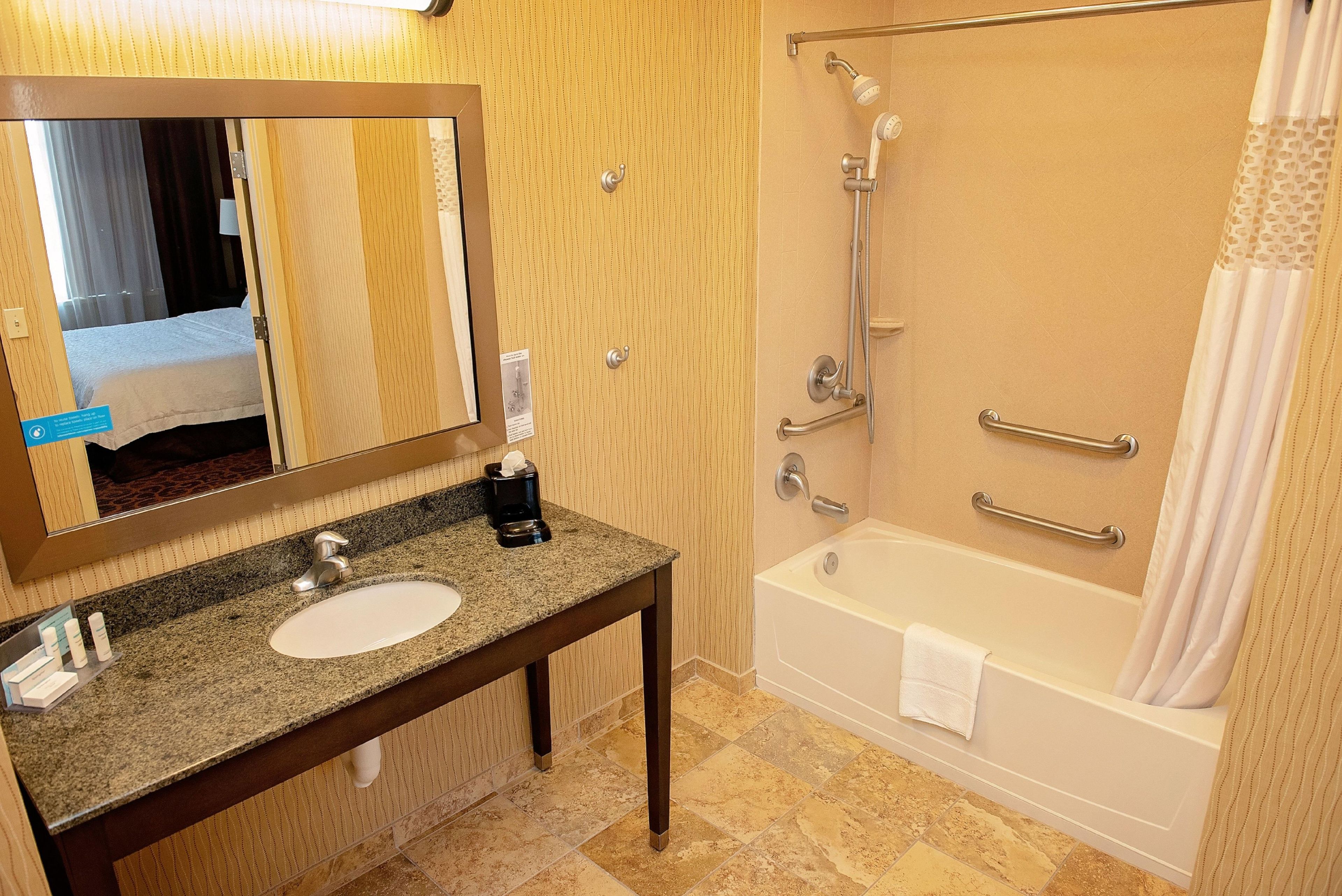 Ein Badezimmer mit Waschbecken, Spiegel, Dusche und Badewanne.