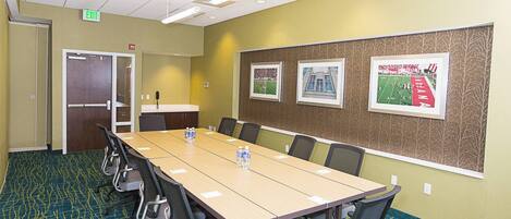 A conference room with a long table, chairs, and framed pictures on the wall.