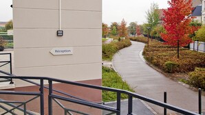A building with a sign reading "Residhome Appartement" and a "Réception" sign below it.