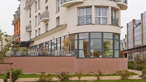 A multi-story hotel with balconies, large windows, and a curved facade.