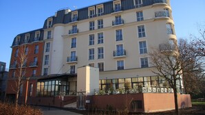 A multi-story hotel with balconies, large windows, and a modern architectural design.
