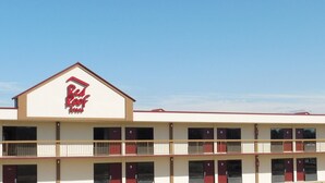 A motel with a red roof and a sign that reads "Red Roof Inn." It has multiple floors with balconies and a flat roof. - Red Roof Inn Fredericksburg South (Fredericksburg)