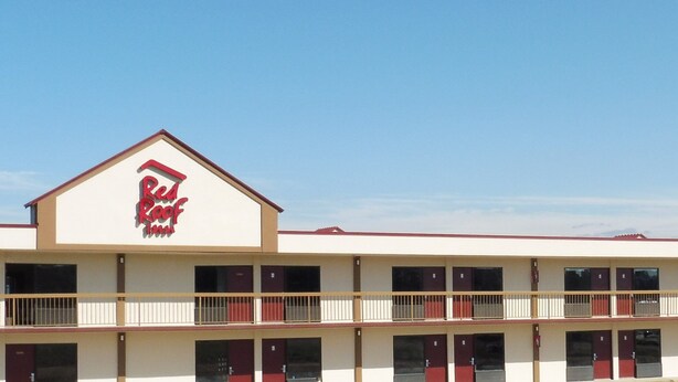 A motel with a red roof and a sign that reads "Red Roof Inn." It has multiple floors with balconies and a flat roof. - Red Roof Inn Fredericksburg South (Fredericksburg)