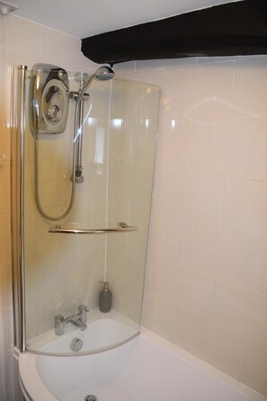 A glass-enclosed shower with a handheld showerhead and a handheld faucet. - Sweetbriar Cottage B&B and Camping (Skipton)