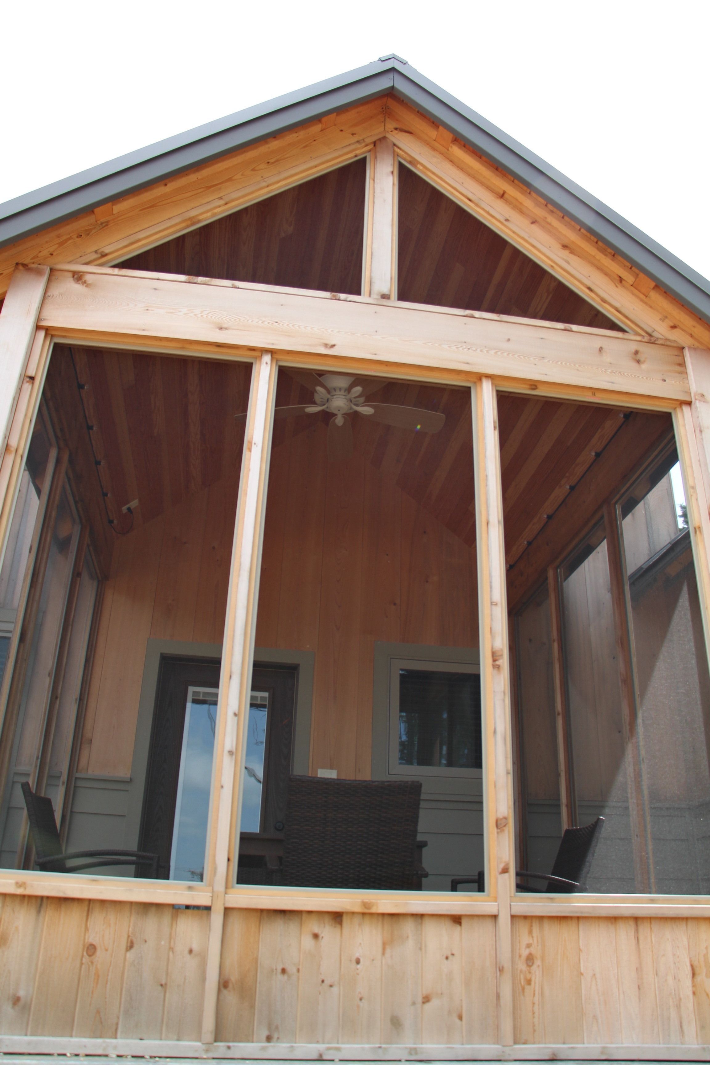 A wooden structure with a sloped roof and large windows.
