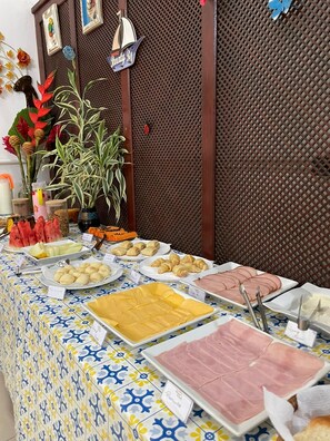 Una mesa de buffet con diversos alimentos y una planta decorativa.