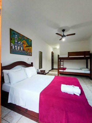 A hotel room with a single bed, a bunk bed, a ceiling fan, a painting, and a tiled floor. - Pousada Alecrim Dourado (Paraty)