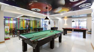 Enjoy a game of pool or socialize with friends in this modern recreational area, featuring a pool table and comfortable seating.