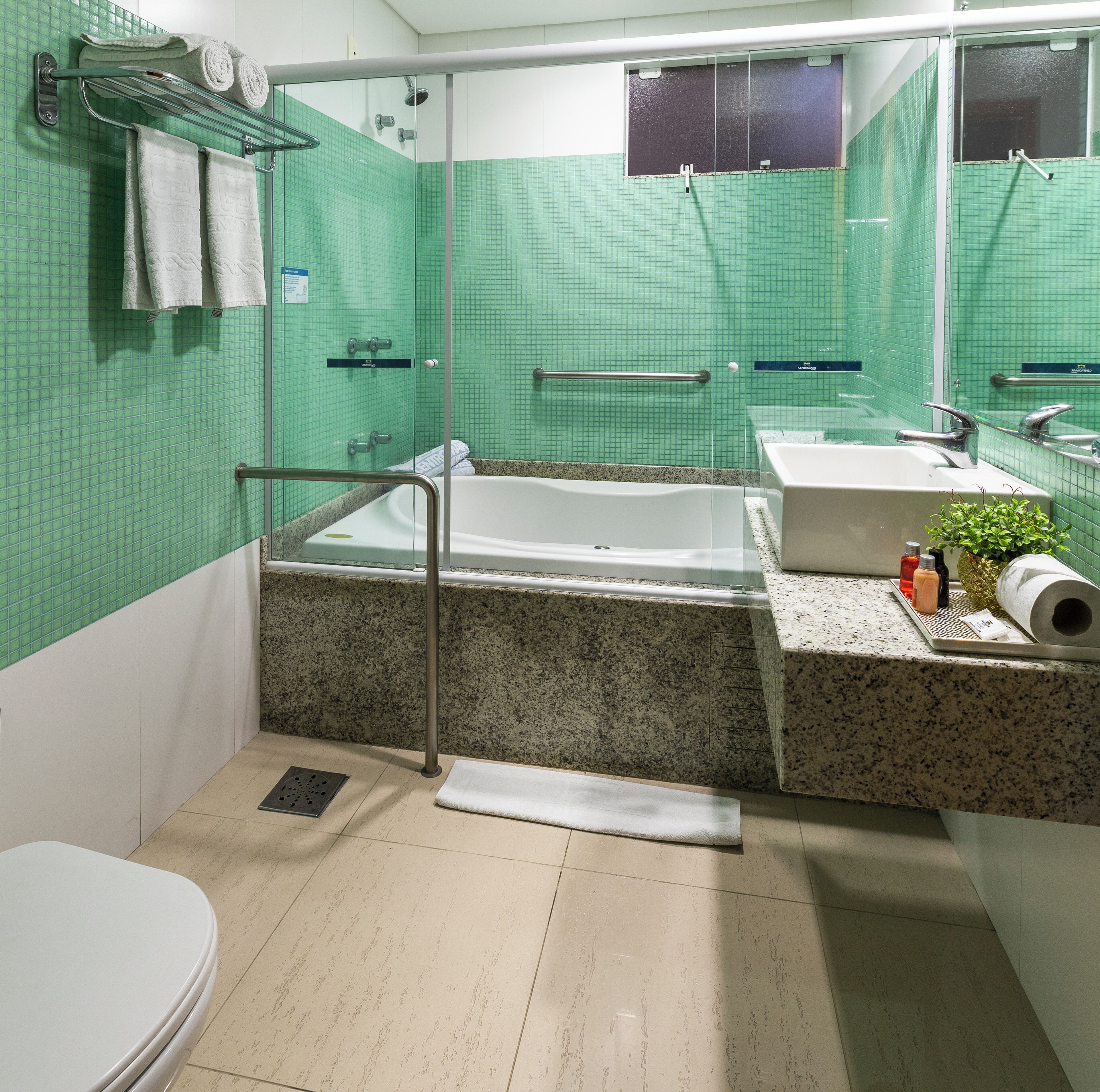 Une salle de bain équipée d’une douche, d’une baignoire, d’un lavabo et de toilettes.