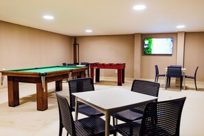 A room with a pool table, a billiards table, and a TV mounted on the wall. - El Aram Beach Express (Maceió)