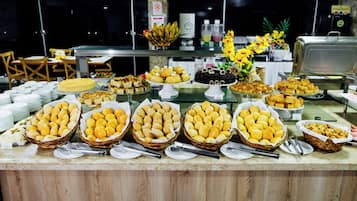 A buffet with various food items and a decorative flower arrangement.