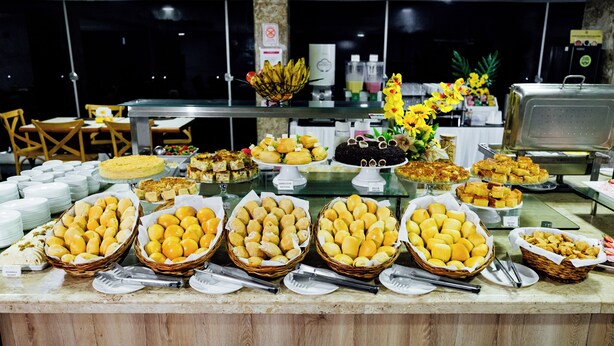 A buffet with various food items and a decorative flower arrangement.