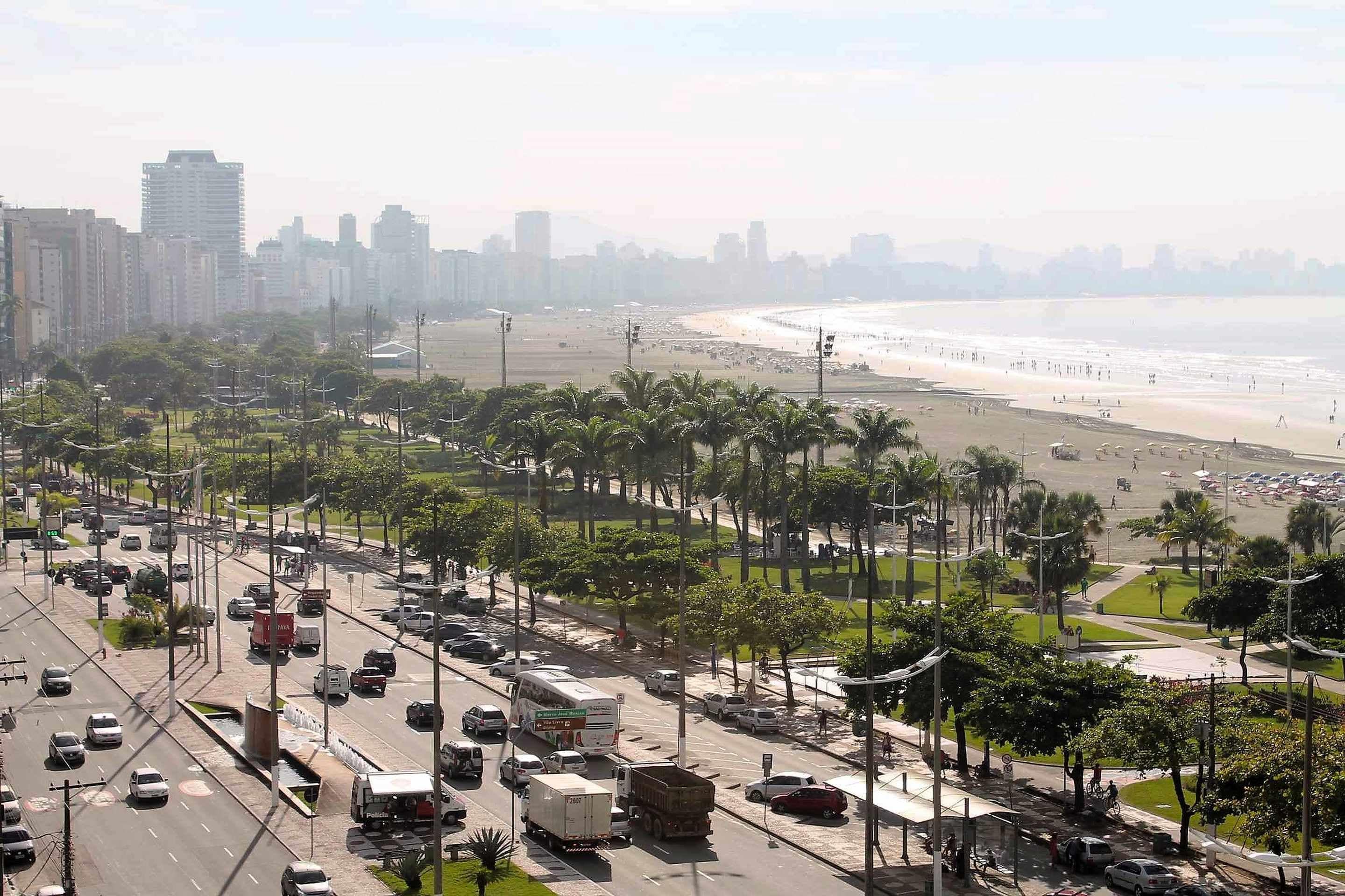 A busy urban street with a beach in the background.