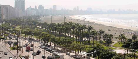 A busy urban street with a beach in the background.