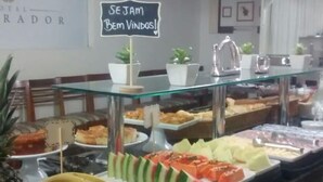 A buffet with various food items, including fruits and pastries, and a sign that reads "SEJAM Bem Vindos!". - Hotel Imperador (Santos)