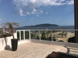 Un balcón con vista a la playa y una isla distante.