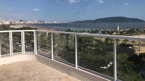 A balcony with a view of a beach, city skyline, and mountains. - Hotel Imperador (Santos)