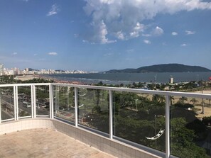 A balcony with a view of a beach, city skyline, and mountains. - Hotel Imperador (Santos)