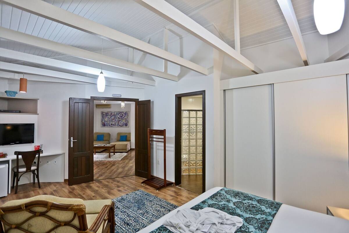 A spacious room with a bed, a desk, and a TV.