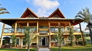 A two-story building with a symmetrical facade, balconies, and a well-maintained lawn.