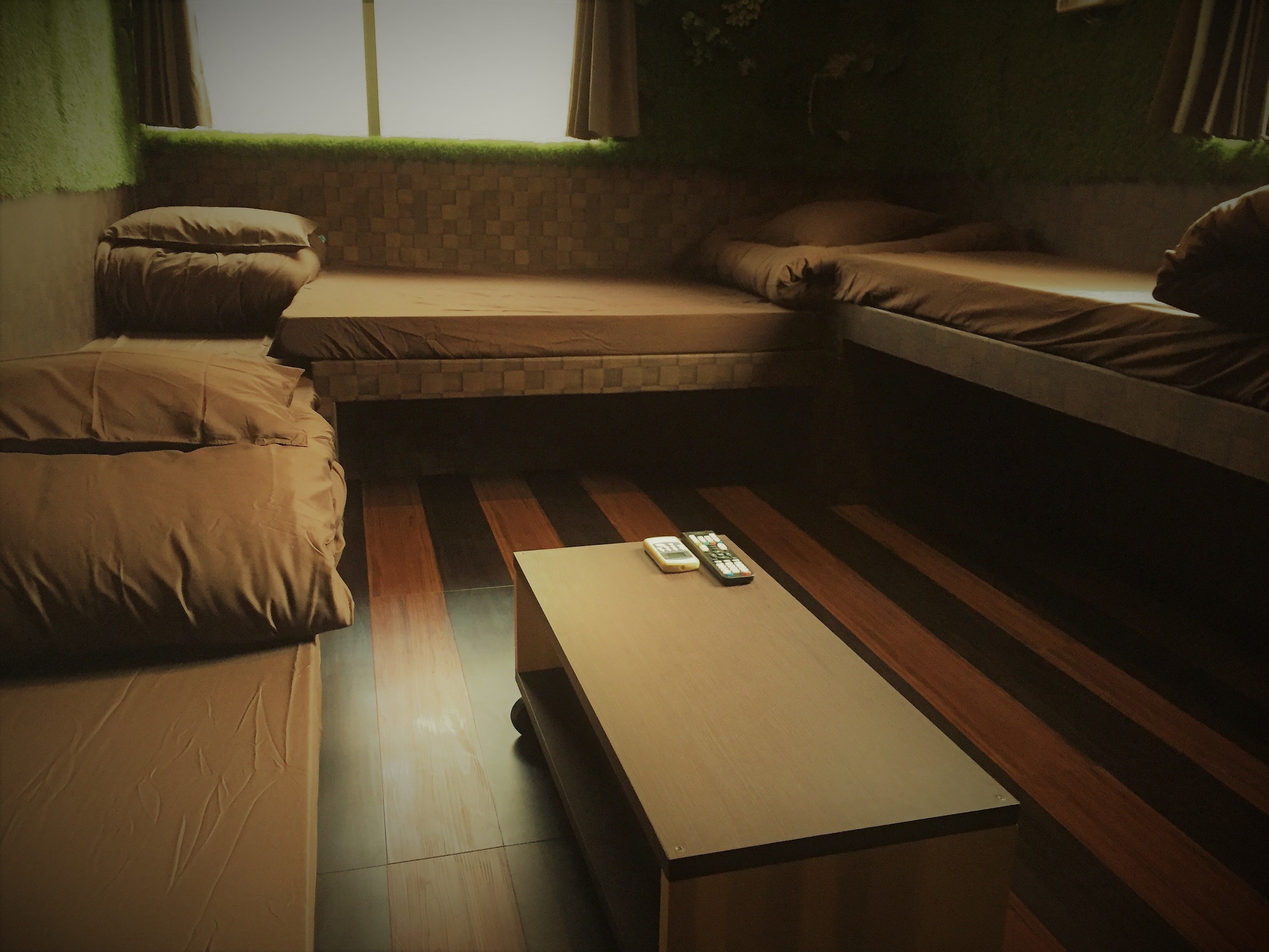 Una habitación acogedora con una cama, un sofá y una mesita con controles remotos.
