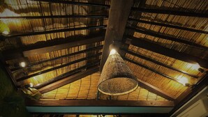 A room with a bamboo ceiling and a hanging light fixture. - Lohas Villa - Hostel (Naha)