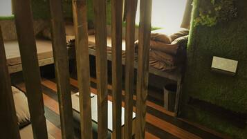 Una stanza con un letto, un tavolino e una parete decorata con un motivo a foglia verde.