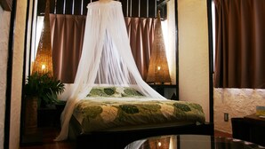A room with a bed under a canopy, a potted plant, and a wall-mounted air conditioner. - Lohas Villa - Hostel (Naha)