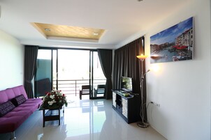 Habitación triple de lujo, 2 habitaciones | Zona de estar | Una televisión de pantalla plana