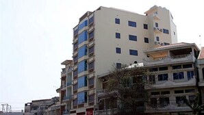 Un edificio de varios pisos con balcones y techo plano.