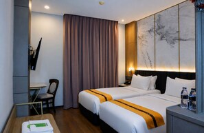 A hotel room with two beds, a desk, a chair, a TV, and a marble wall. - Oria Hotel Jakarta (Jakarta)