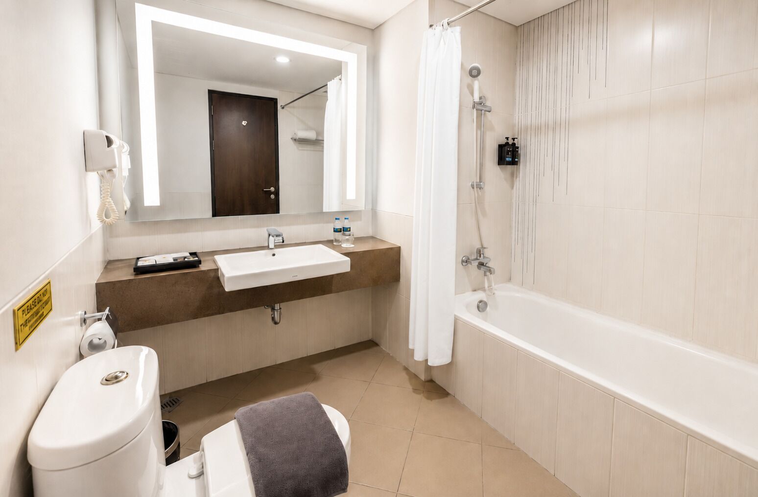 A modern bathroom with a sink, toilet, and bathtub.