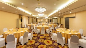 A large conference room with multiple round tables, white chairs, and a carpet with a floral pattern. - Oria Hotel Jakarta (Jakarta)