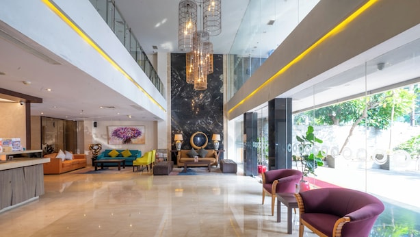 A spacious lobby with a high ceiling, modern furniture, and a large window offering a view of the outdoors. - Oria Hotel Jakarta (Jakarta)