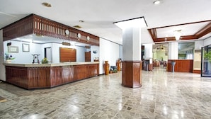 A spacious lobby with a reception desk, stone flooring, and a modern ceiling design. - Sahid Manado (Manado)