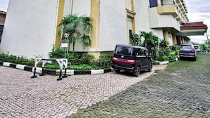 A multi-story building with a flat facade and a central vertical yellow stripe. - Sahid Manado (Manado)