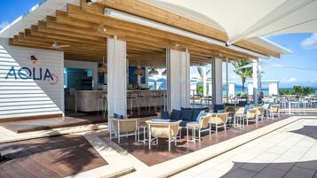 An outdoor bar area with seating and a view of the ocean.