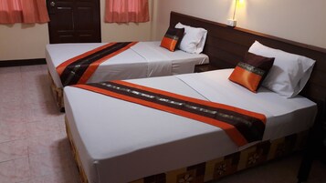 Two single beds with white linens and orange decorative bands, a wooden headboard, and a pink curtain.