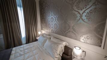 Une chambre d’hôtel avec un grand lit, une table de chevet, une lampe et un papier peint à motifs.