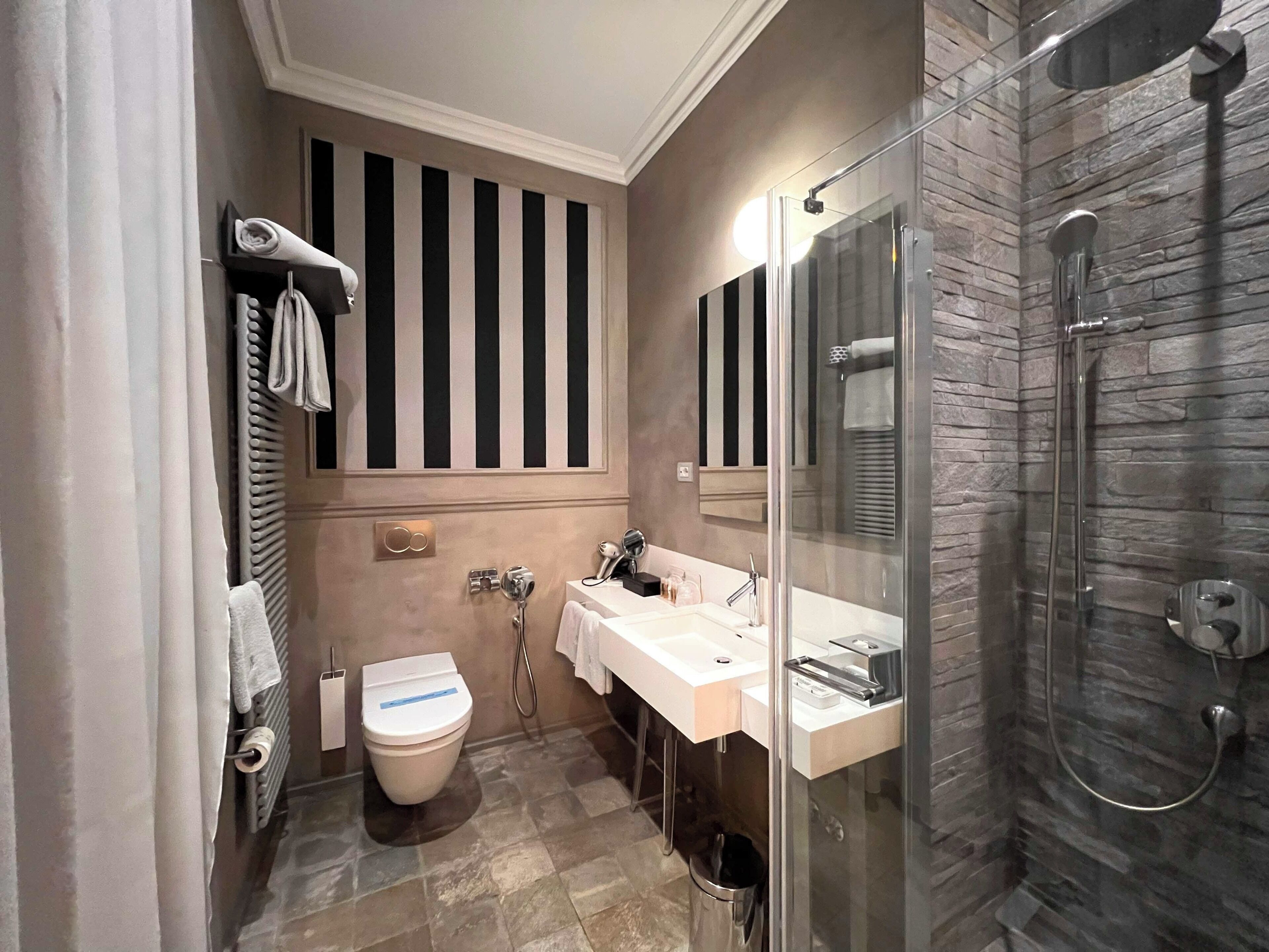 A bathroom with a toilet, sink, and shower.